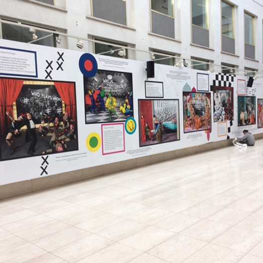 Messe Event: Kunstausstellung mit Fotos und Texten an einer Wand.