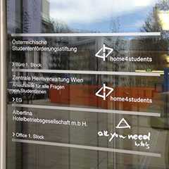 Leitsystem: Beschriftete Glastür mit Firmenlogos und Stockwerk-Angaben. Prallschutz.