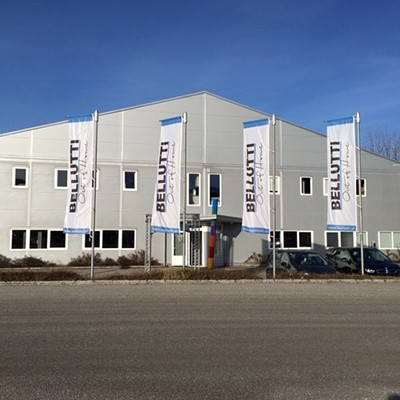 Bellutti Gebäude mit Fahnen. Bürogebäude und Firmensitz.