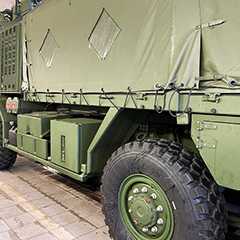 Militär: Abdeckung eines olivgrünen Militärfahrzeugs mit Plane und groben Reifen.