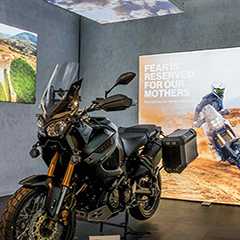 Pixlip Go Präsentationssystem: Schwarzes Motorrad vor beleuchtetem Werbedisplay. Messebau und Präsentation.