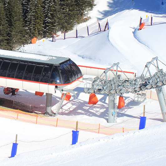 Sicherheit im Winter: Skilift mit Prallschutz auf Skipiste.