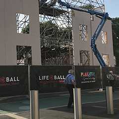 Außenwerbung: Bauzaun mit Life Ball Werbung vor Baustelle mit Gerüst und Hebebühne.