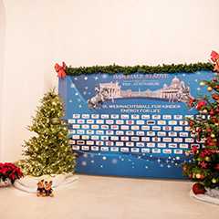 Indoor Event: Weihnachtsdeko mit Christbäumen und Sponsorenwand. Festliche Atmosphäre für Events.