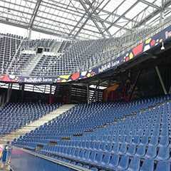 Innenansicht SonderEventbau: Blaue Sitze im Stadion. Zeltbau-Konstruktion im Hintergrund.