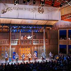 Bühnenbild Globe Wien. Musiker, Publikum und Bühne im Theater. Filmkulisse.