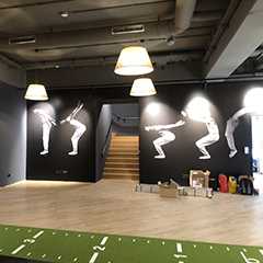 Innenraum mit Prallschutz-Wandbildern. Treppe im Hintergrund. Wintersport-Shop.