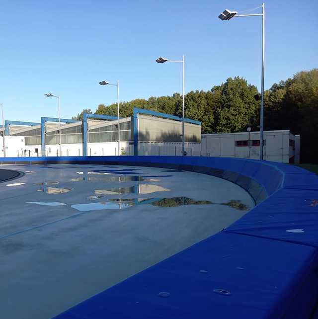 Eischnelllaufbahn mit Softbandensystem. Shorttrack-Arena mit blauen Banden und Reflexionen.