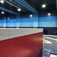 Trampolinhalle: Prallschutz in Rot/Weiß. Blaue Wände, sichere Polsterung für Sprungspaß.