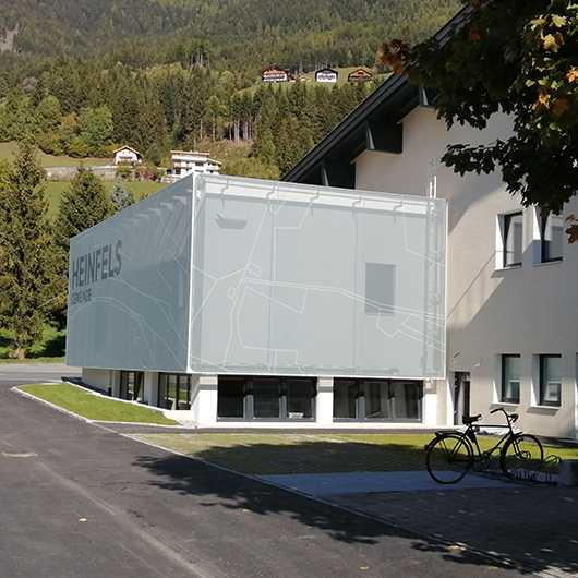Textile Fassade Heinfels: Gemeindegebäude mit Textilfassade und Fahrrad vor dem Gebäude.